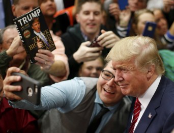 U.S. Republican presidential candidate Donald Trump takes a selfie with a supporter as he prepares to leave a campaign event in Anderson, South Carolina October 19, 2015. REUTERS/Chris Keane TPX IMAGES OF THE DAY - RTS5663